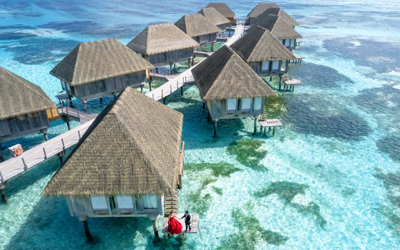 Overwater bungalows connected by wooden walkways in the Maldives